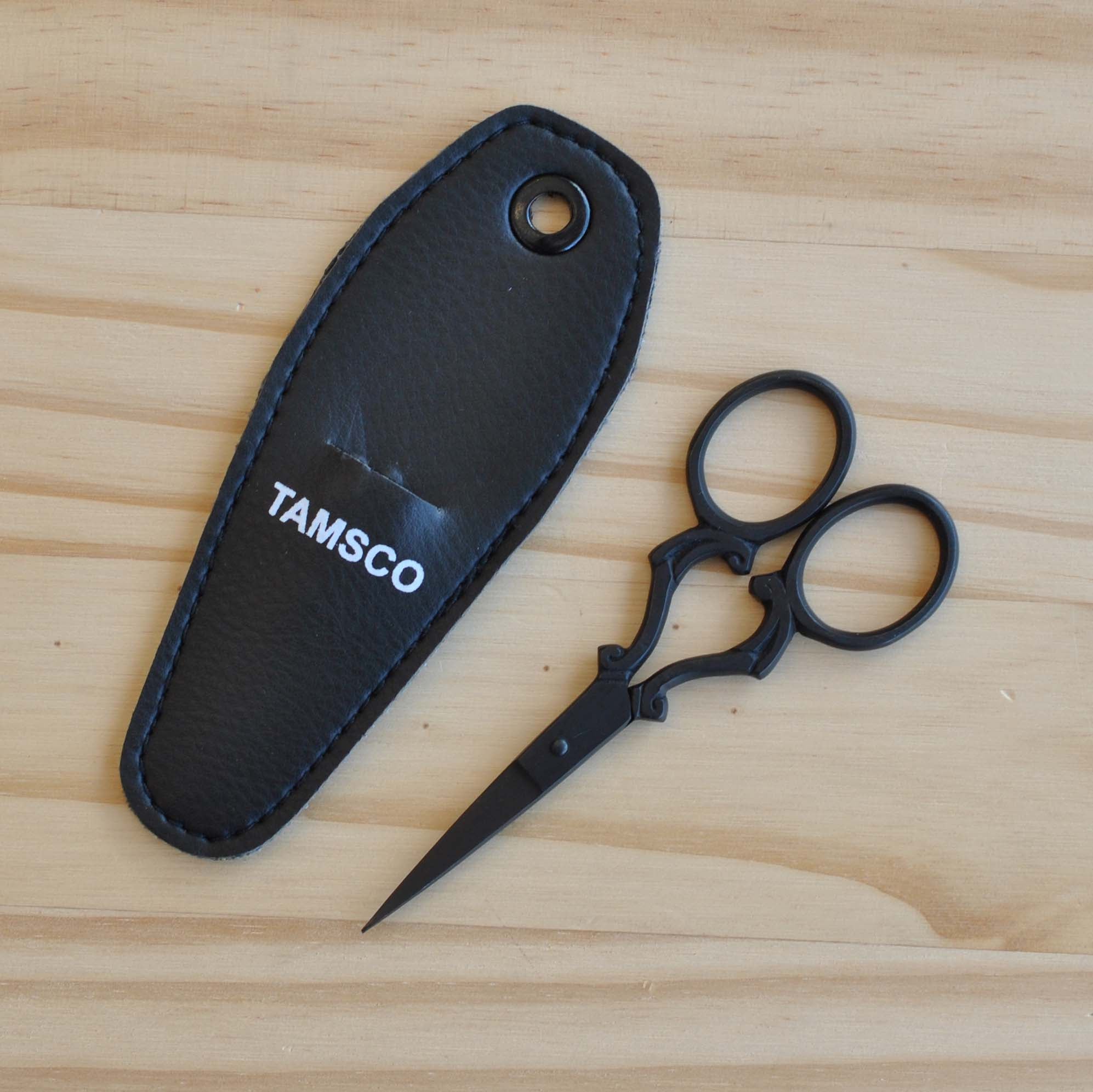 Black embroidery scissors with scroll design on handles.