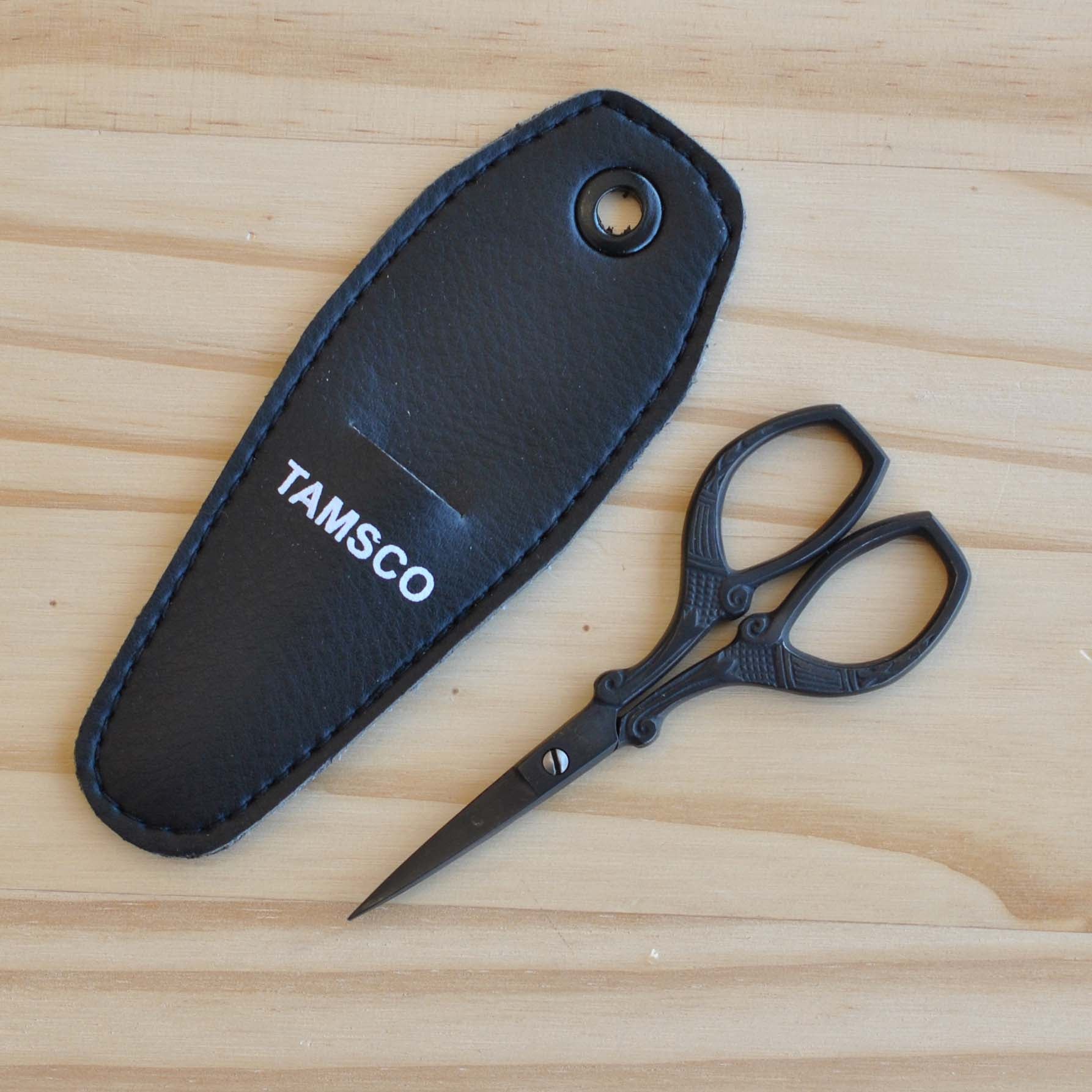Matte black embroidery scissors with designed handles.