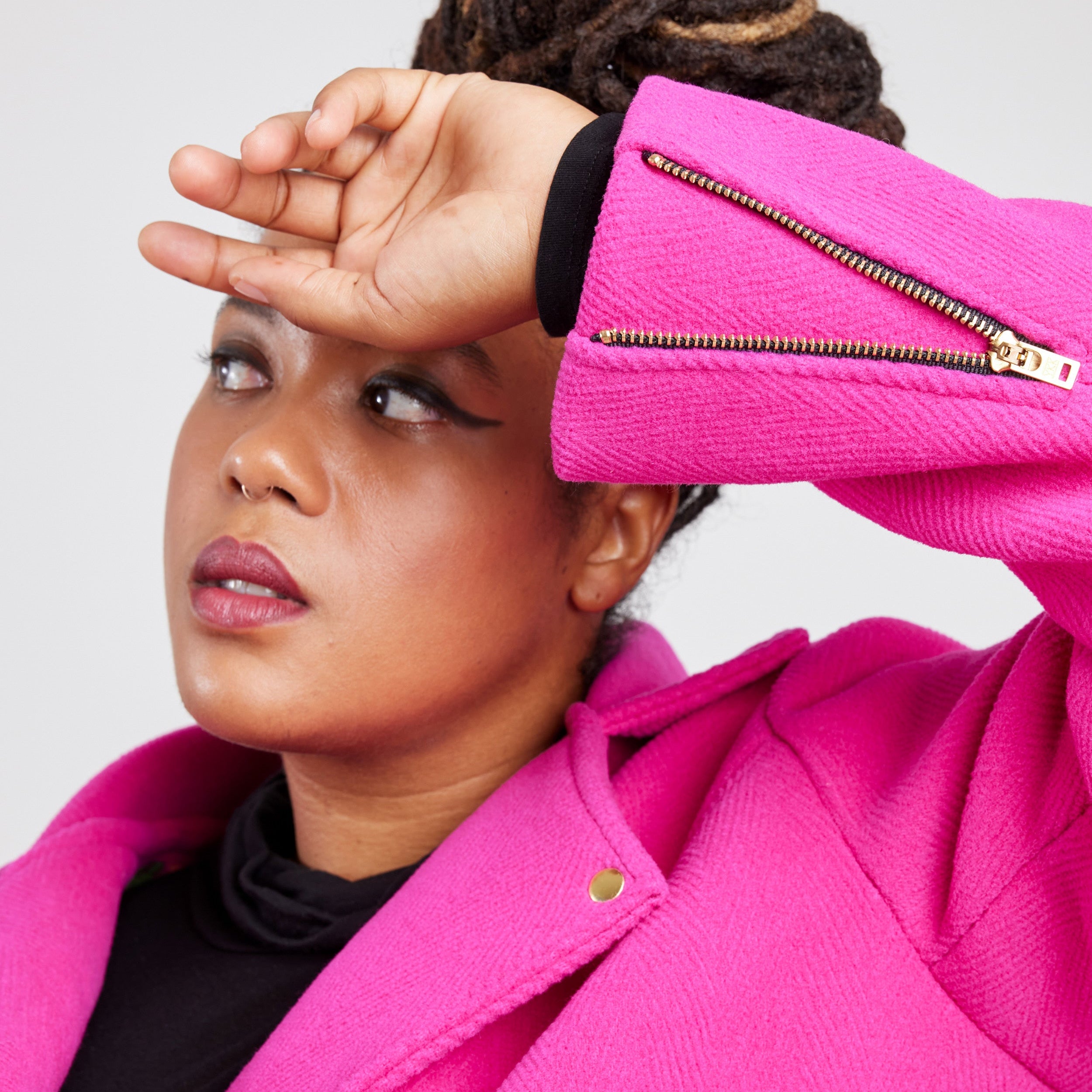Person wearing a bright pink jacket with a white background. This biker jacket is the Canton Moto Jacket sewing pattern from Cashmerette.