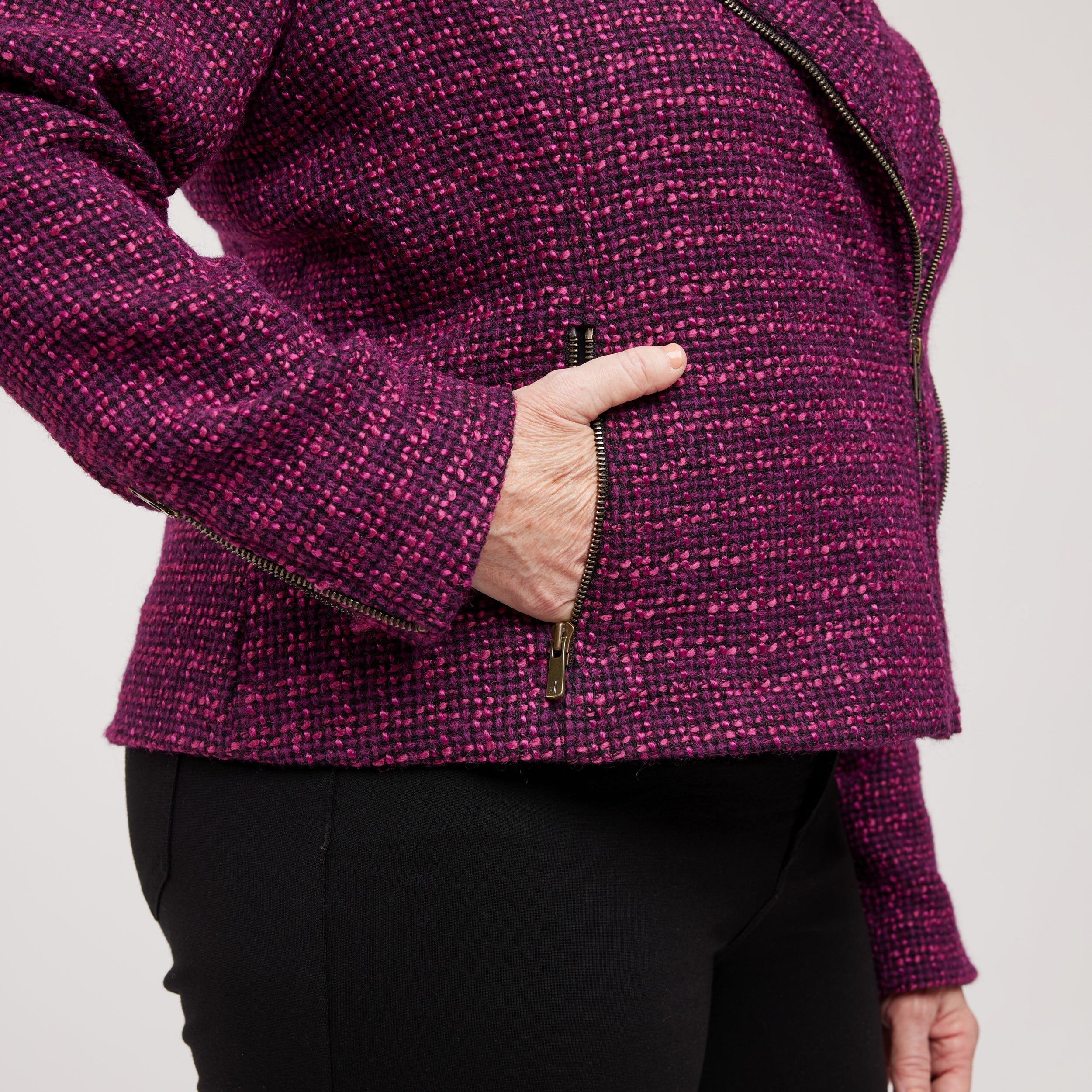 Person wearing a purple textured jacket with a plain background. This biker jacket is the Canton Moto Jacket sewing pattern from Cashmerette.