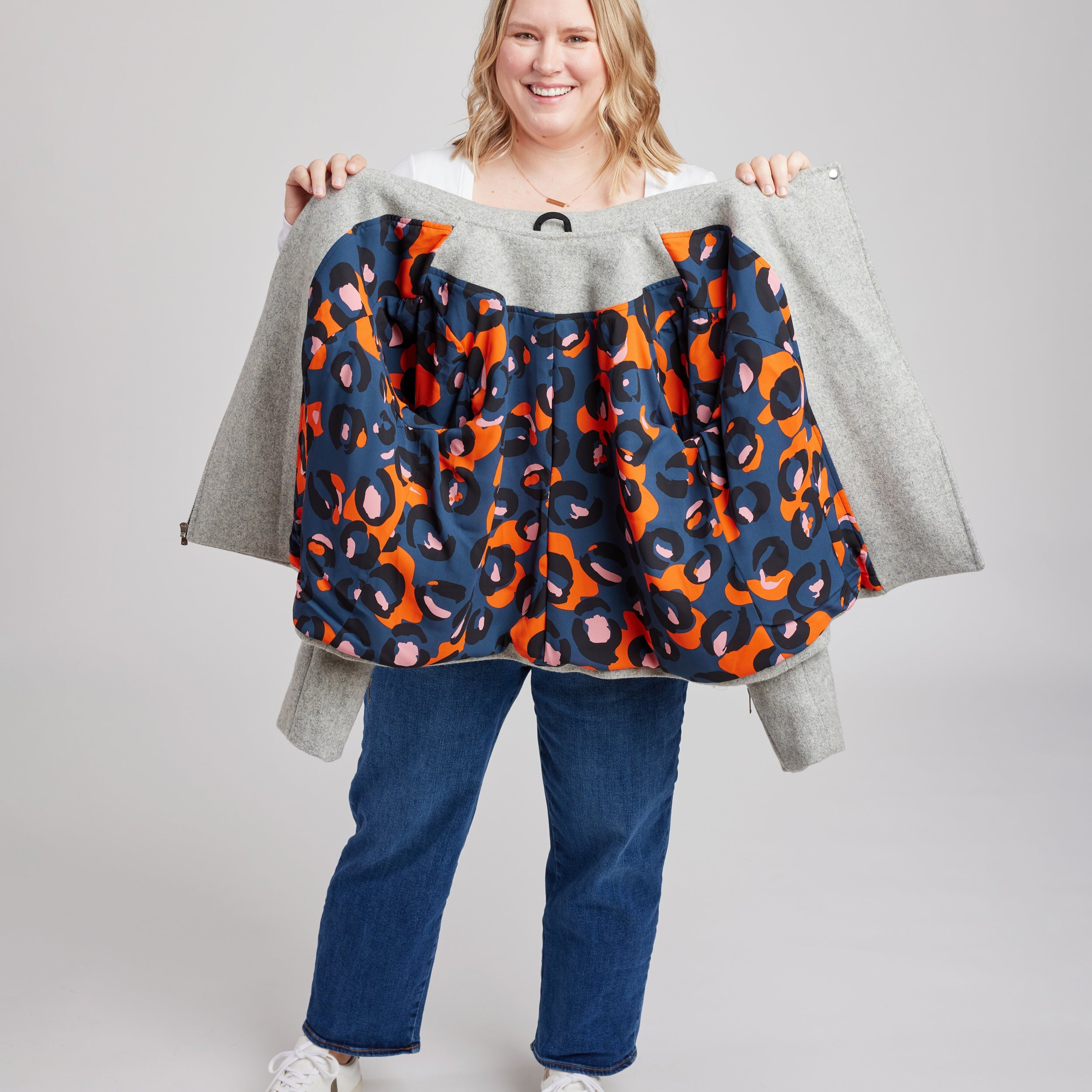 Person holding a colorful patterned jacket against a plain background. This biker jacket is the Canton Moto Jacket sewing pattern from Cashmerette.