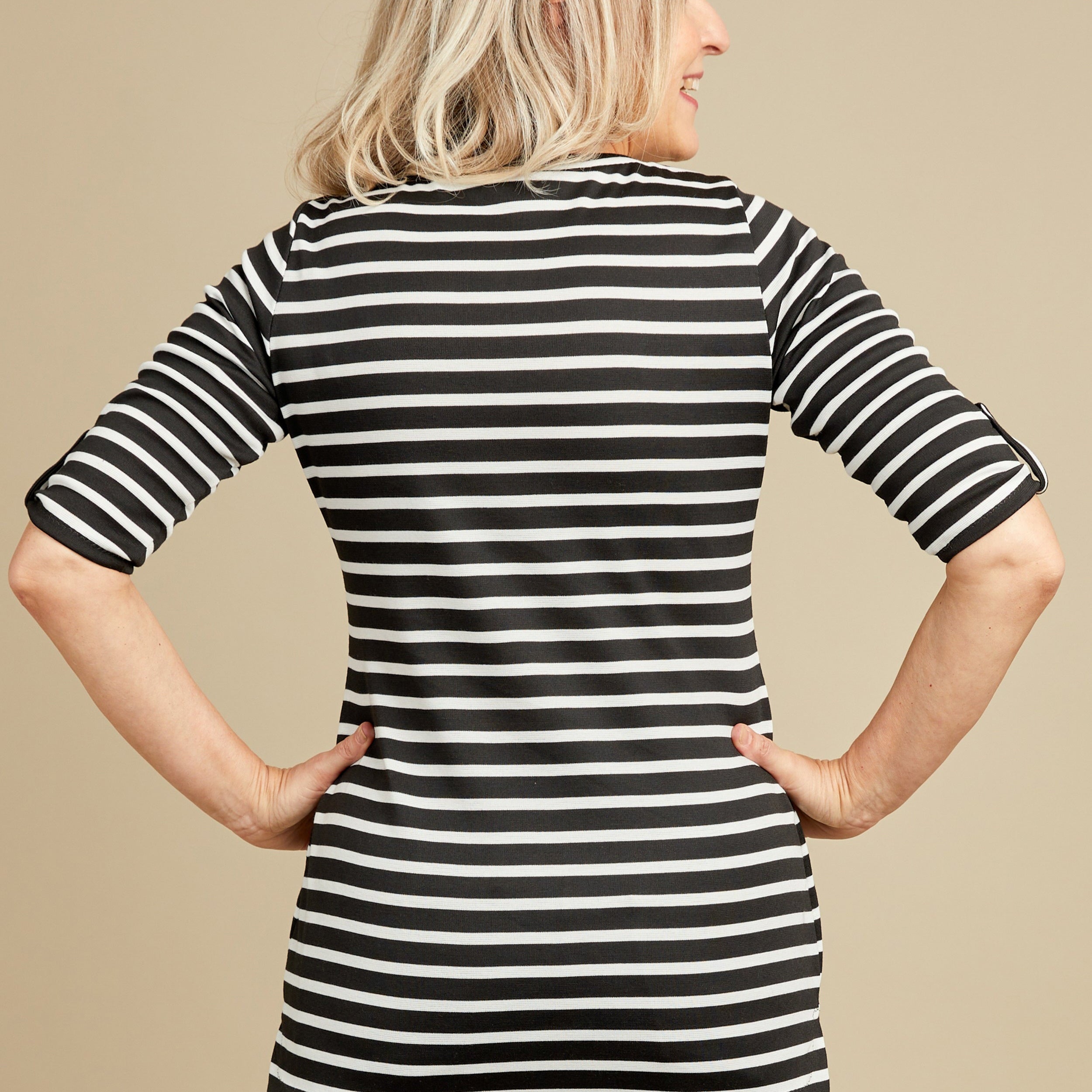 Woman wearing a black and white striped shirt against a beige background. This t-shirt is the Concord T-Shirt sewing pattern from Cashmerette.