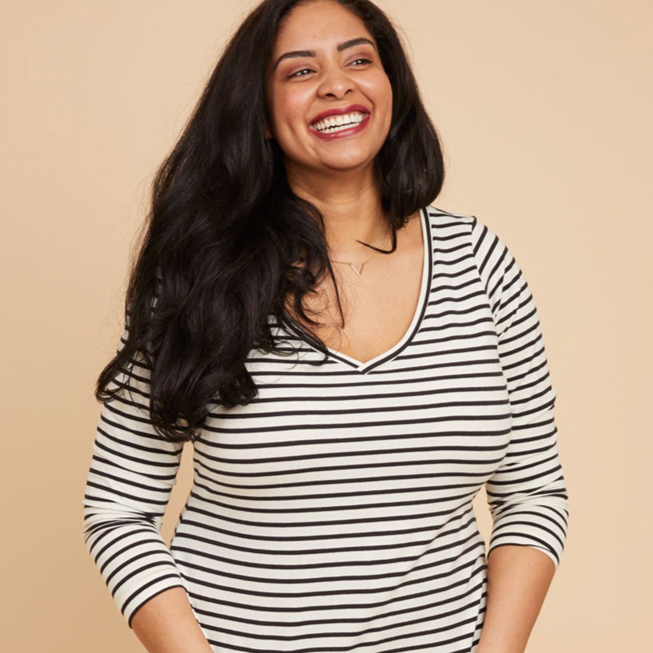 Woman wearing a black and white striped shirt against a beige backgroundThis t-shirt is the Concord T-Shirt sewing pattern from Cashmerette.