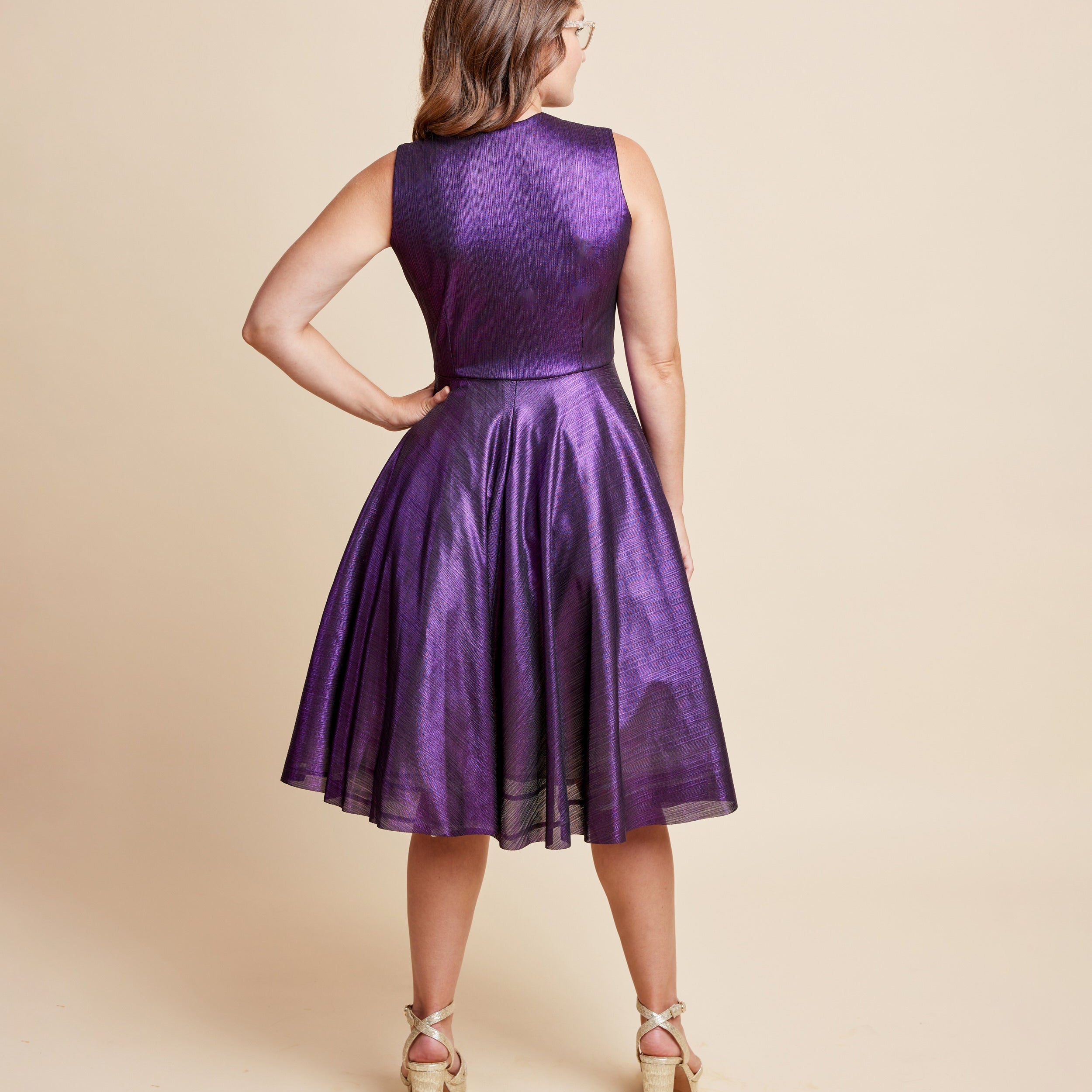 Woman wearing a purple dress against a beige background. This is the Grafton Dress, Top & Skirt sewing pattern from Cashmrette.