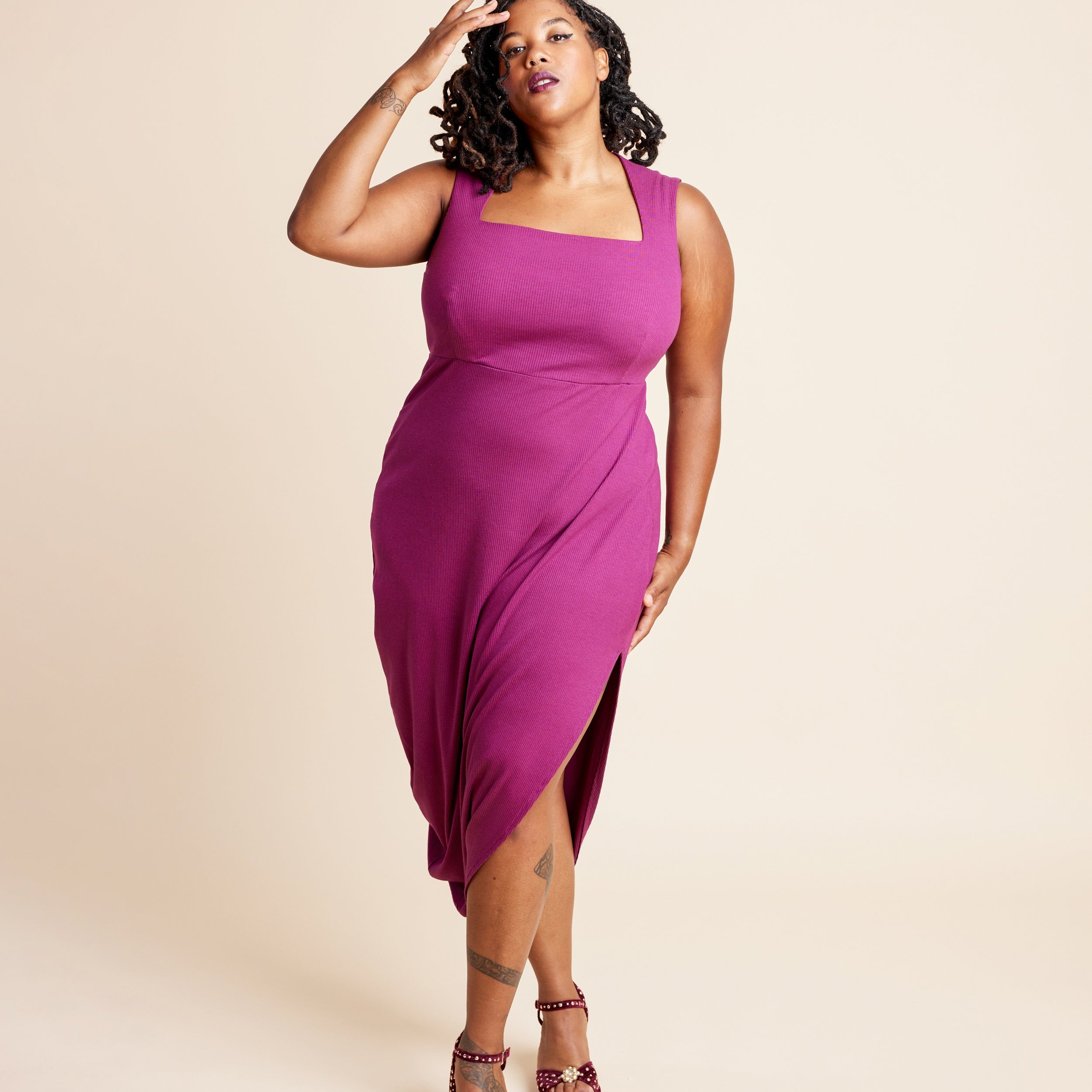 Woman wearing a magenta dress with a beige background. This is the Grafton Dress, Top & Skirt sewing pattern from Cashmerette.