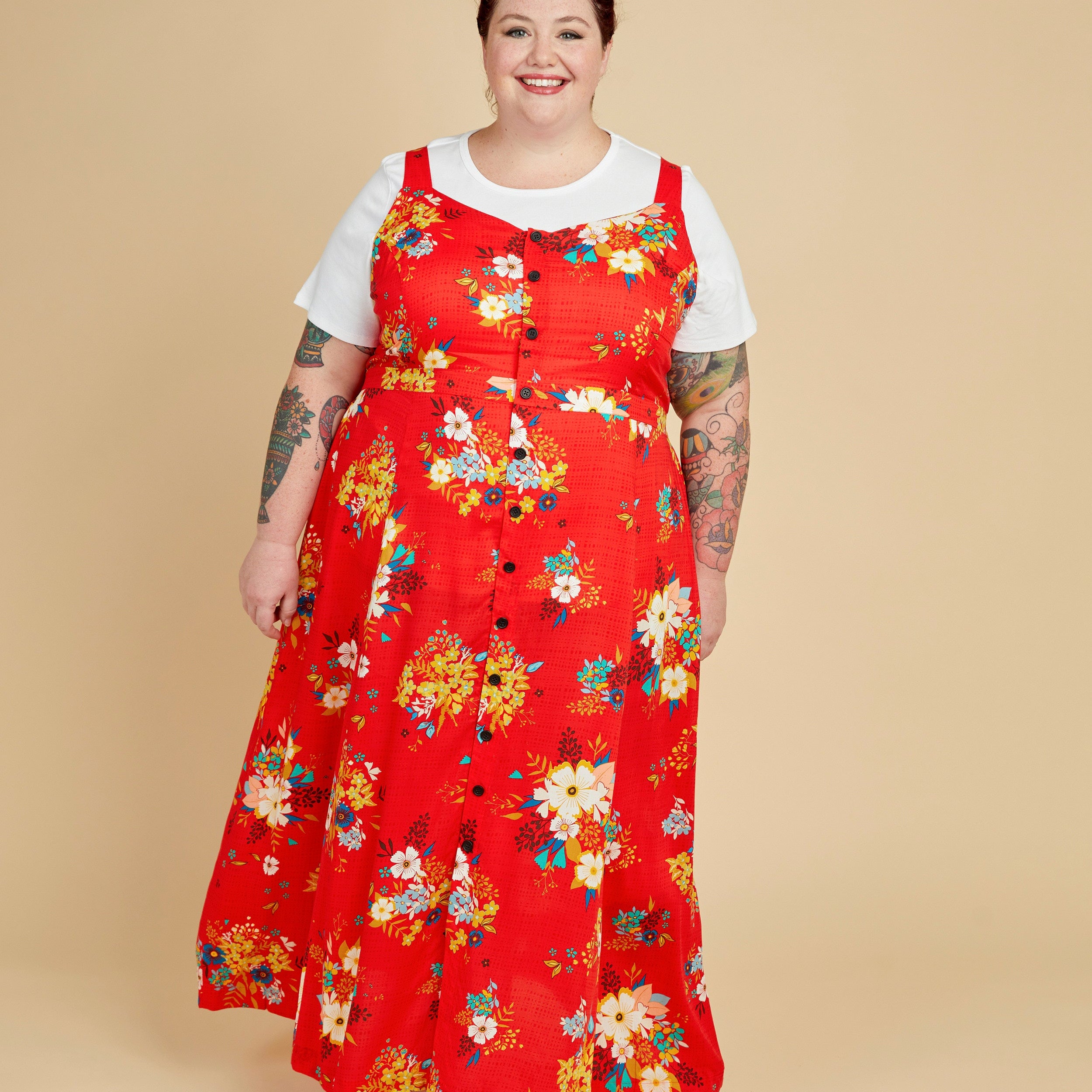 Person wearing a red floral dress on a beige background. This is the Holyoke Maxi Dress & Skirt sewing pattern from Cashmerette.