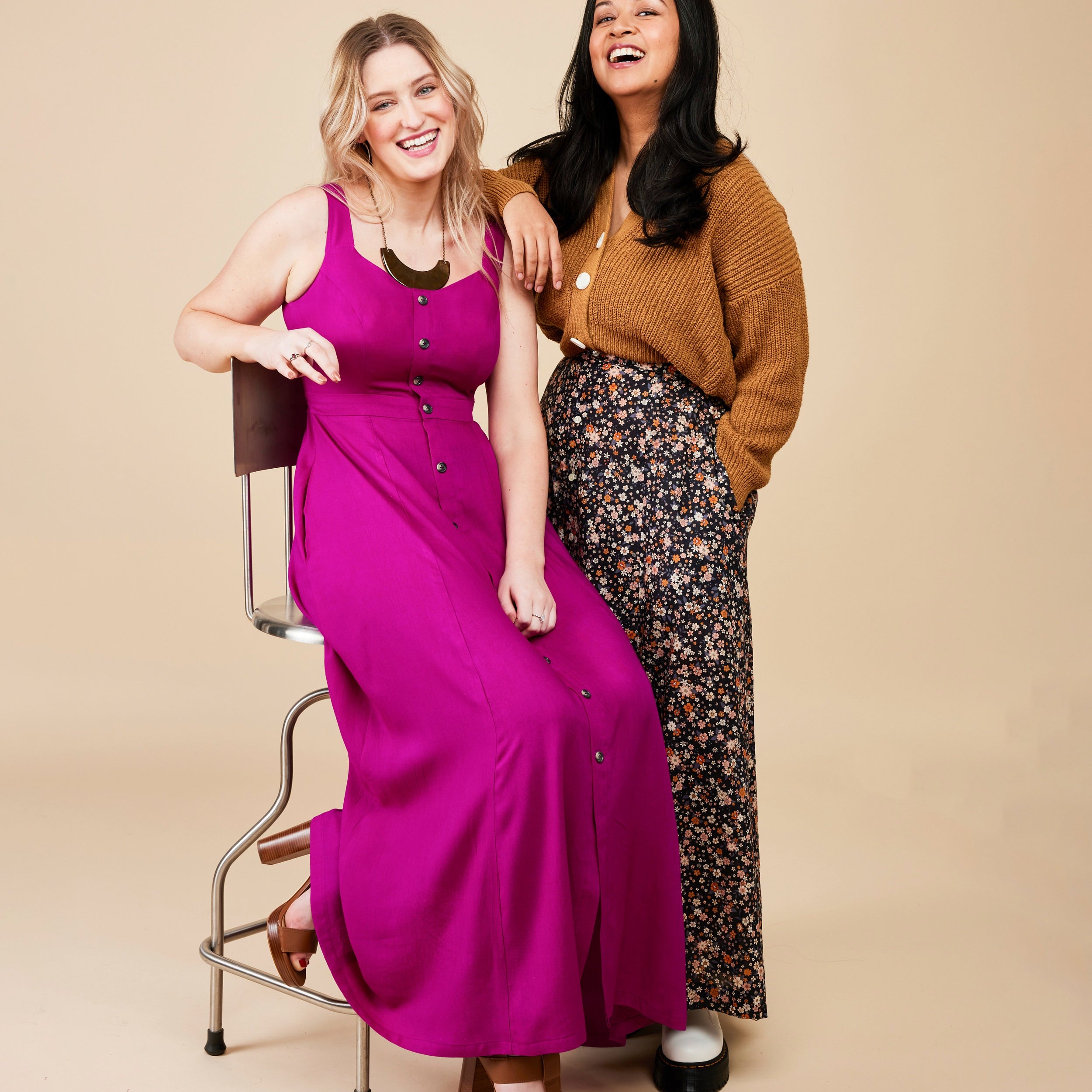 Two women posing together on a beige background. This is the Holyoke Maxi Dress & Skirt sewing pattern from Cashmerette.