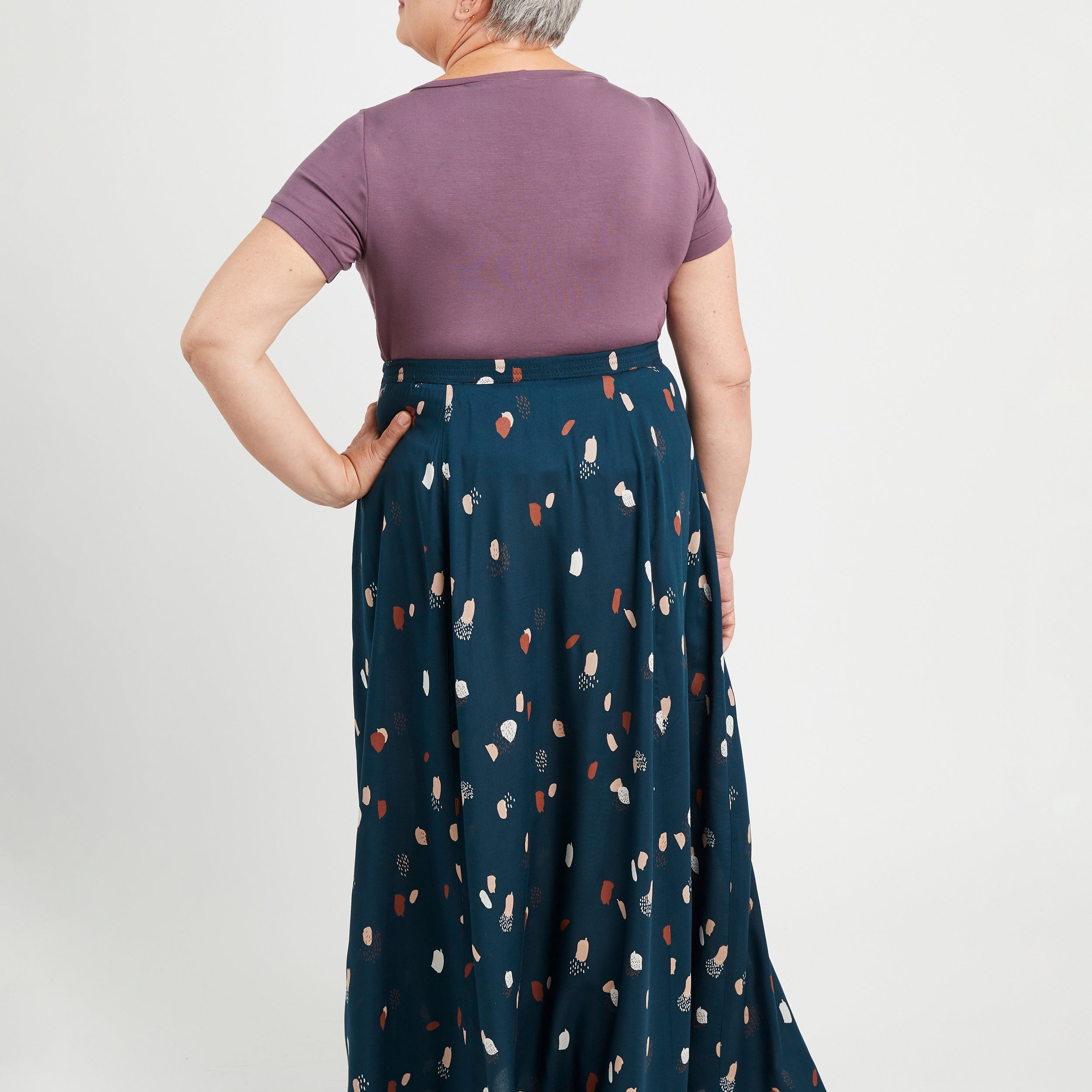 Woman wearing a purple top and blue patterned skirt on a white background. This is the Holyoke Maxi Dress & Skirt sewing pattern from Cashmerette.