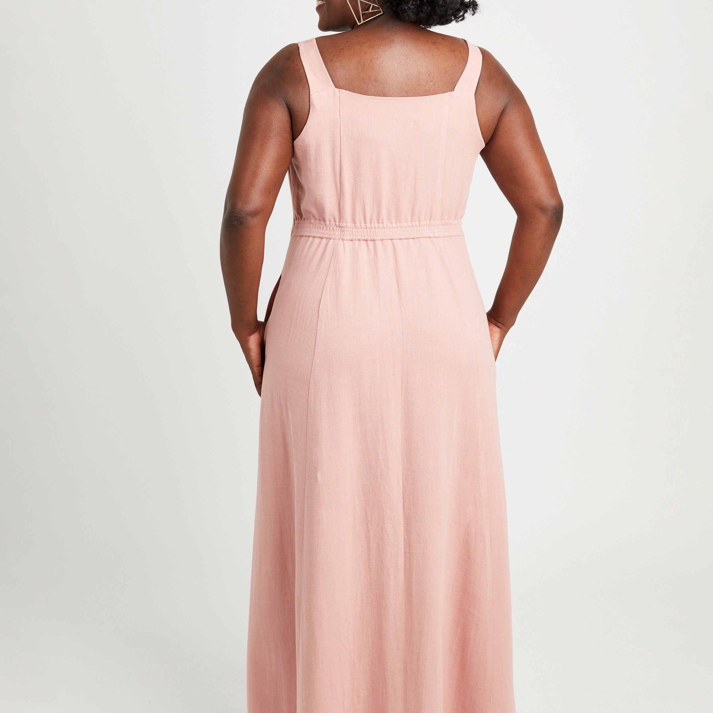 Woman wearing a pink sleeveless dress on a white background. This is the Holyoke Maxi Dress & Skirt sewing pattern from Cashmerette.