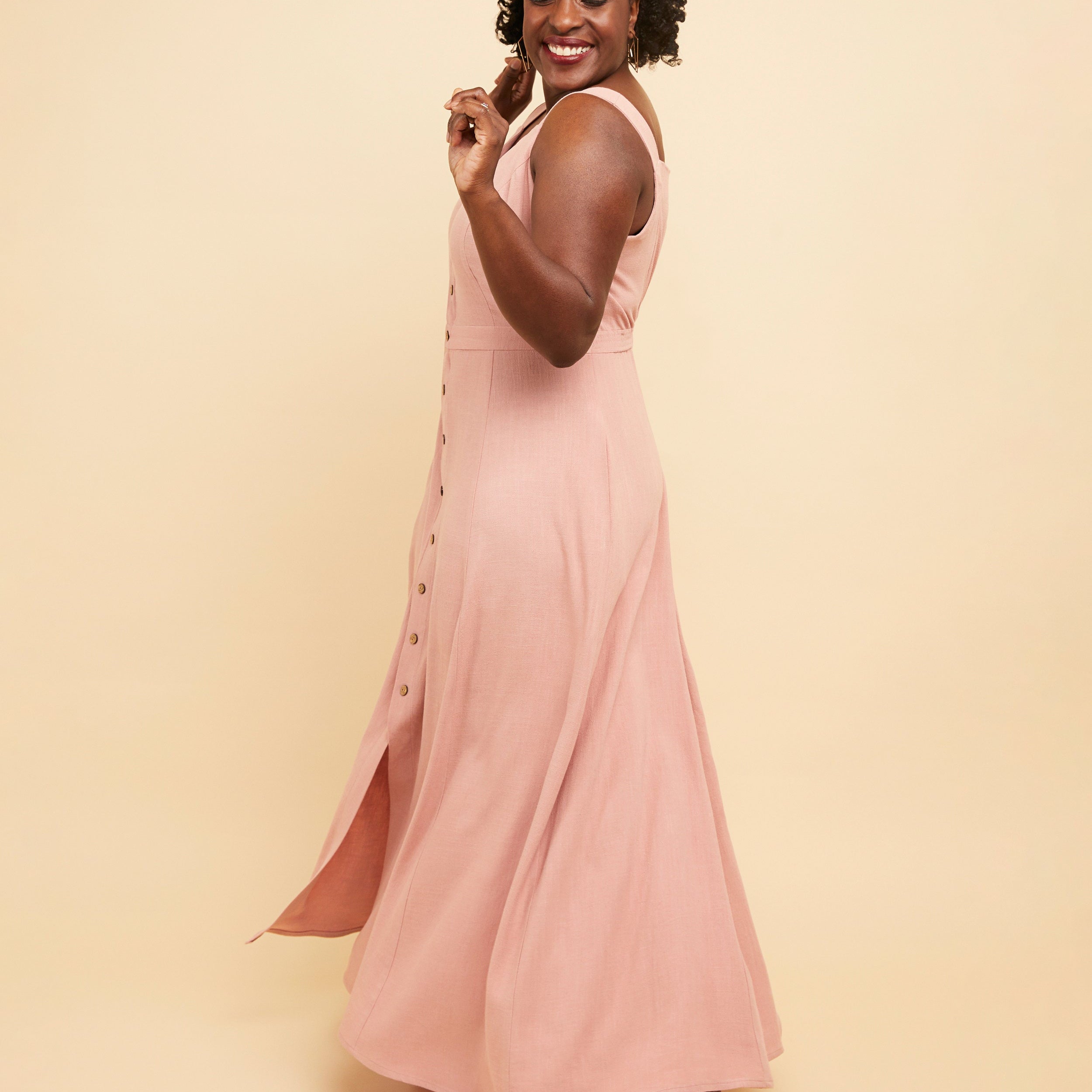 Woman wearing a pink dress against a beige background. This is the Holyoke Maxi Dress & Skirt sewing pattern from Cashmerette.