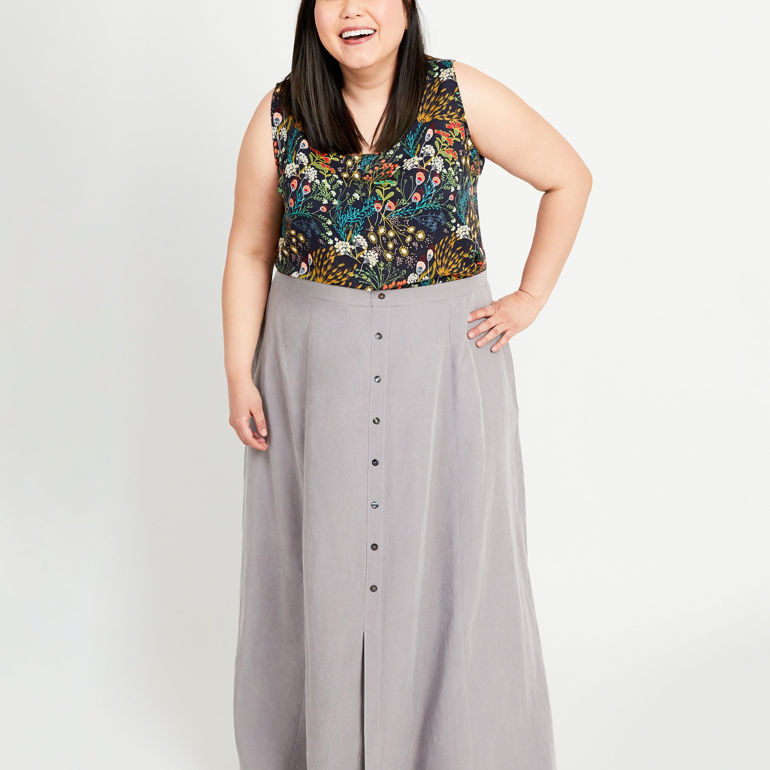 Woman wearing a floral top and gray skirt on a white background. This is the Holyoke Maxi Dress & Skirt sewing pattern from Cashmerette.