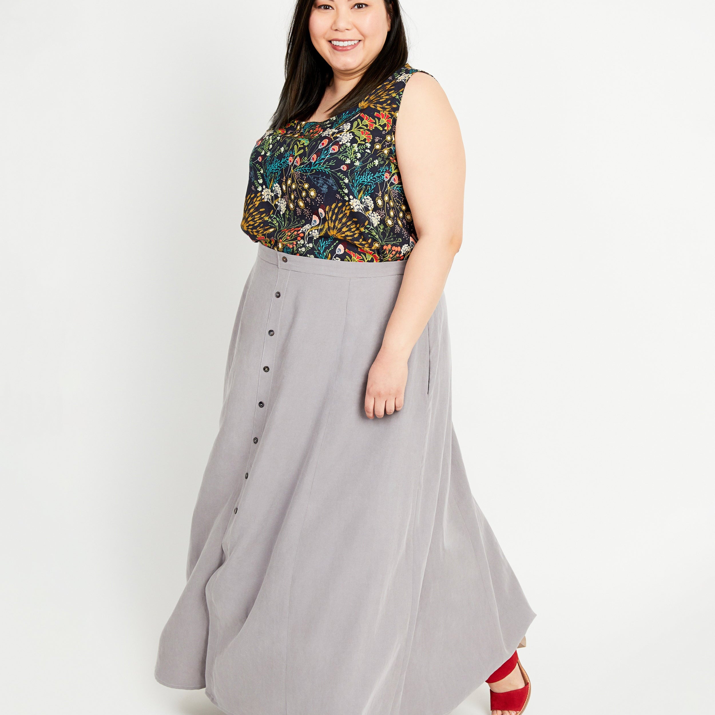 Woman wearing a floral top and gray skirt on a white background. This is the Holyoke Maxi Dress & Skirt sewing pattern from Cashmerette.