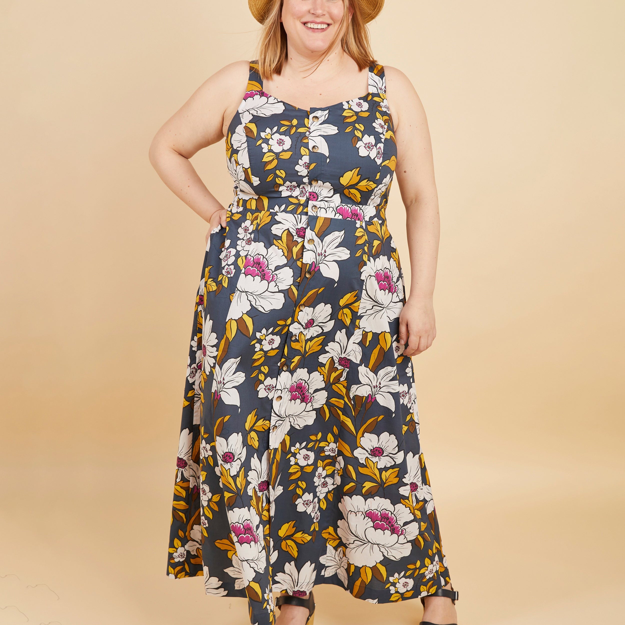 Woman wearing a floral dress with a beige background. This is the Holyoke Maxi Dress & Skirt sewing pattern from Cashmerette.