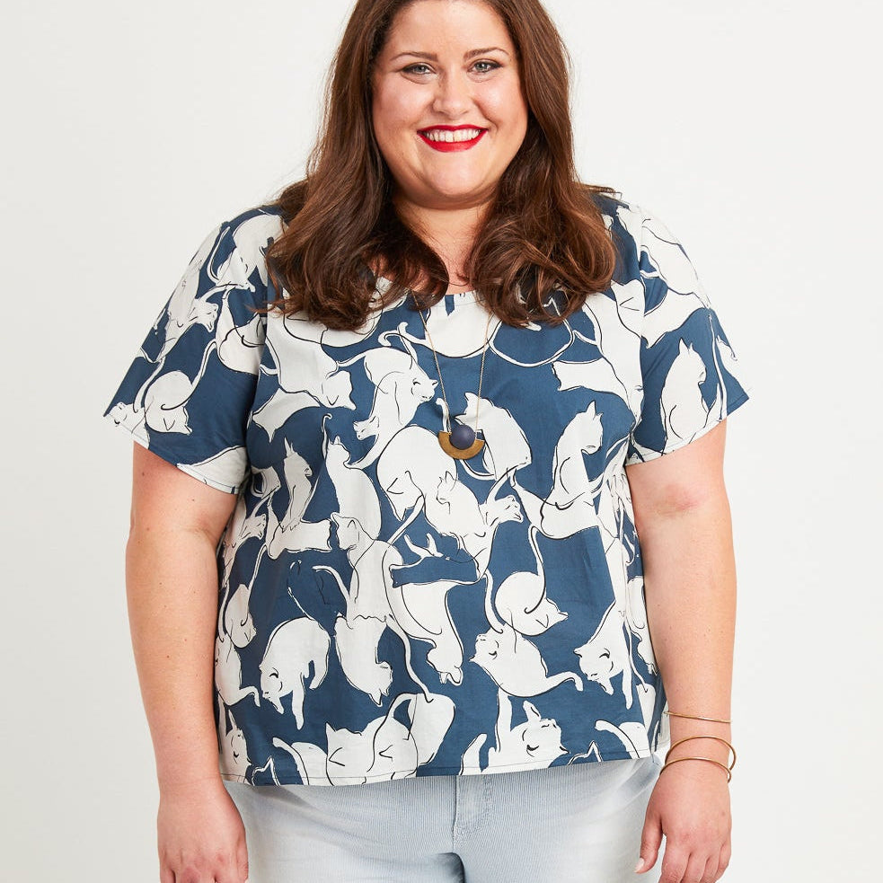 Woman wearing a blue floral blouse and light blue jeans on a white background. This is the Montrose Top sewing pattern from Cashmerette.