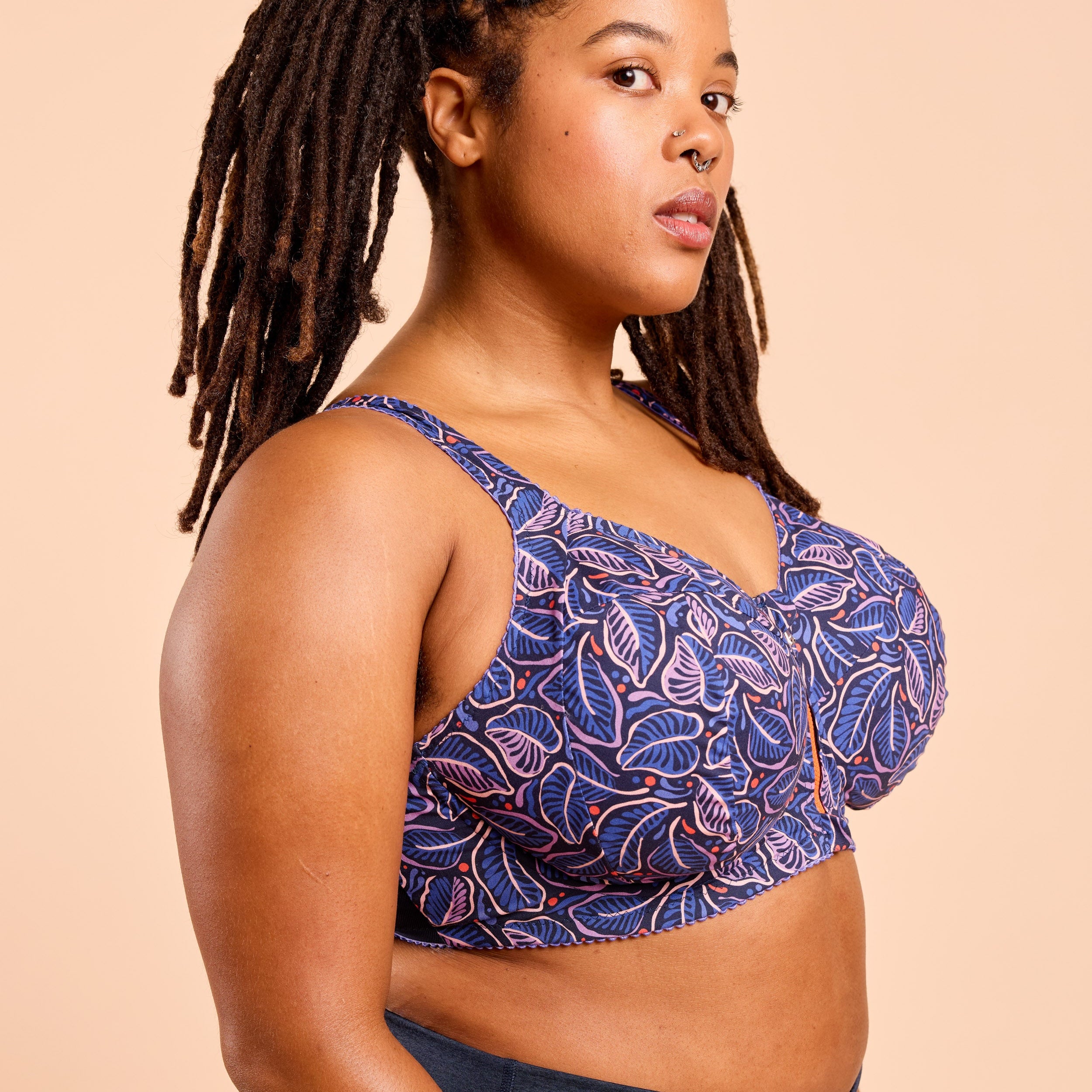 Woman wearing a blue patterned top against a beige background. This is the Cashmerette Somerville Sports Bra sewing pattern for big boobs.