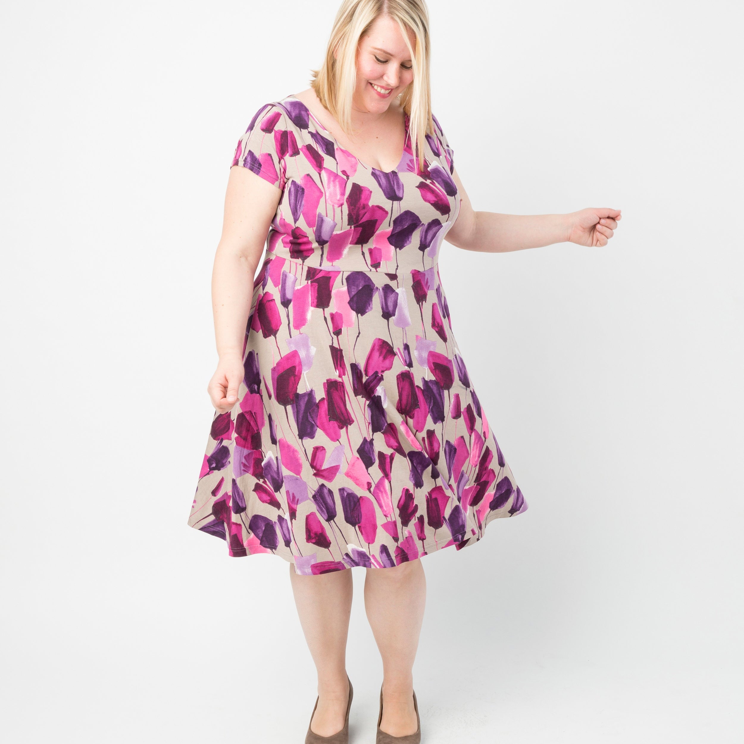 Woman wearing a floral dress on a white background. This dress is the Turner Dress sewing pattern from Cashmerette.
