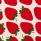Pattern of red strawberries with green leaves on a beige background