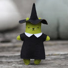 Toy figure of a cat in a witch costume on a wooden surface