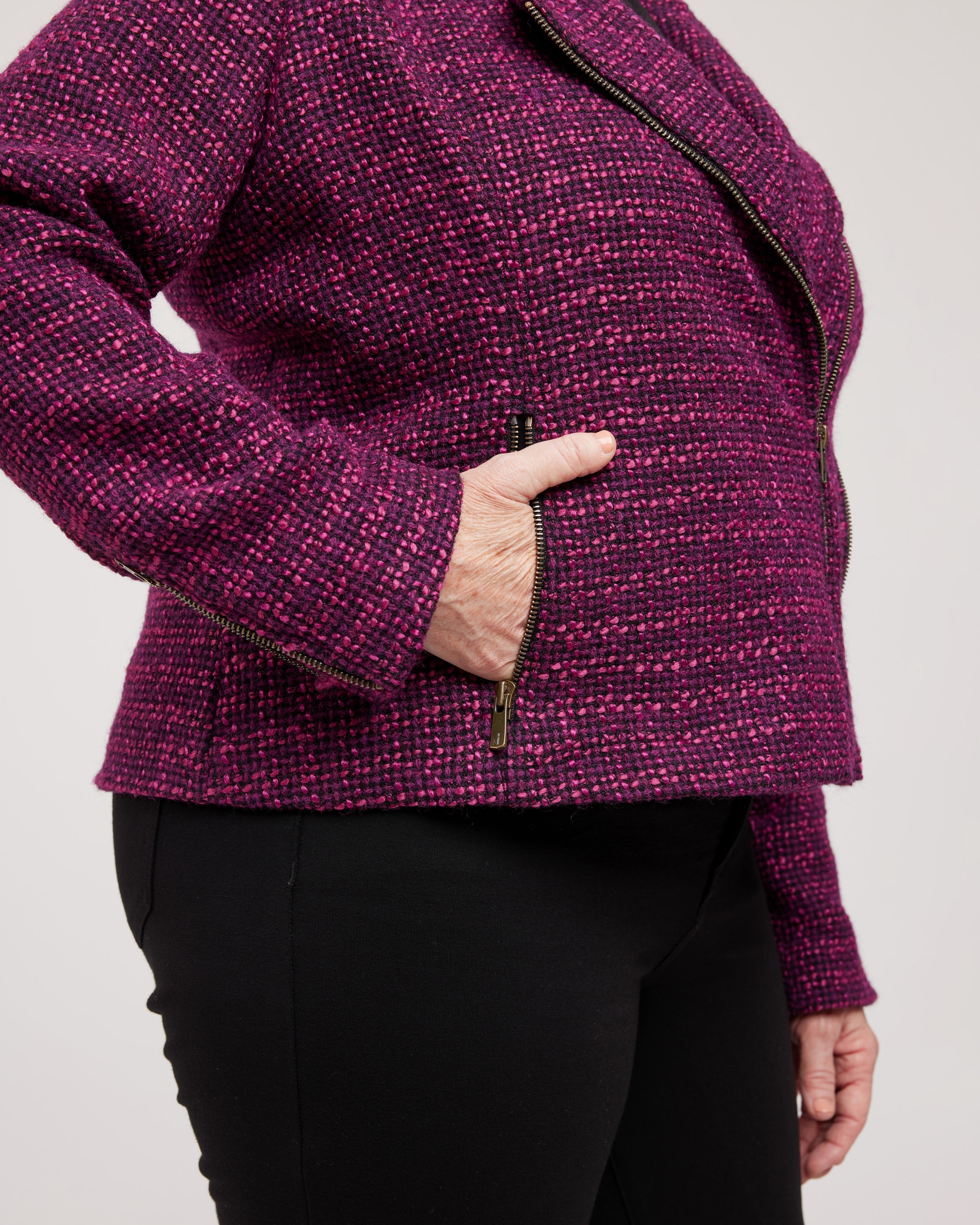 Person wearing a purple textured jacket with a plain background. This biker jacket is the Canton Moto Jacket sewing pattern from Cashmerette.