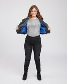 Woman wearing a black jacket with a blue interior, striped shirt, and black pants on a white background. This biker jacket is the Canton Moto Jacket sewing pattern from Cashmerette.