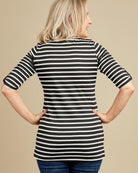 Woman wearing a black and white striped shirt against a beige background. This t-shirt is the Concord T-Shirt sewing pattern from Cashmerette.