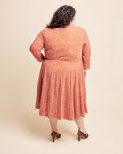 Woman wearing a patterned dress on a beige background. This is the Grafton Dress, Top & Skirt sewing pattern from Cashmerette.