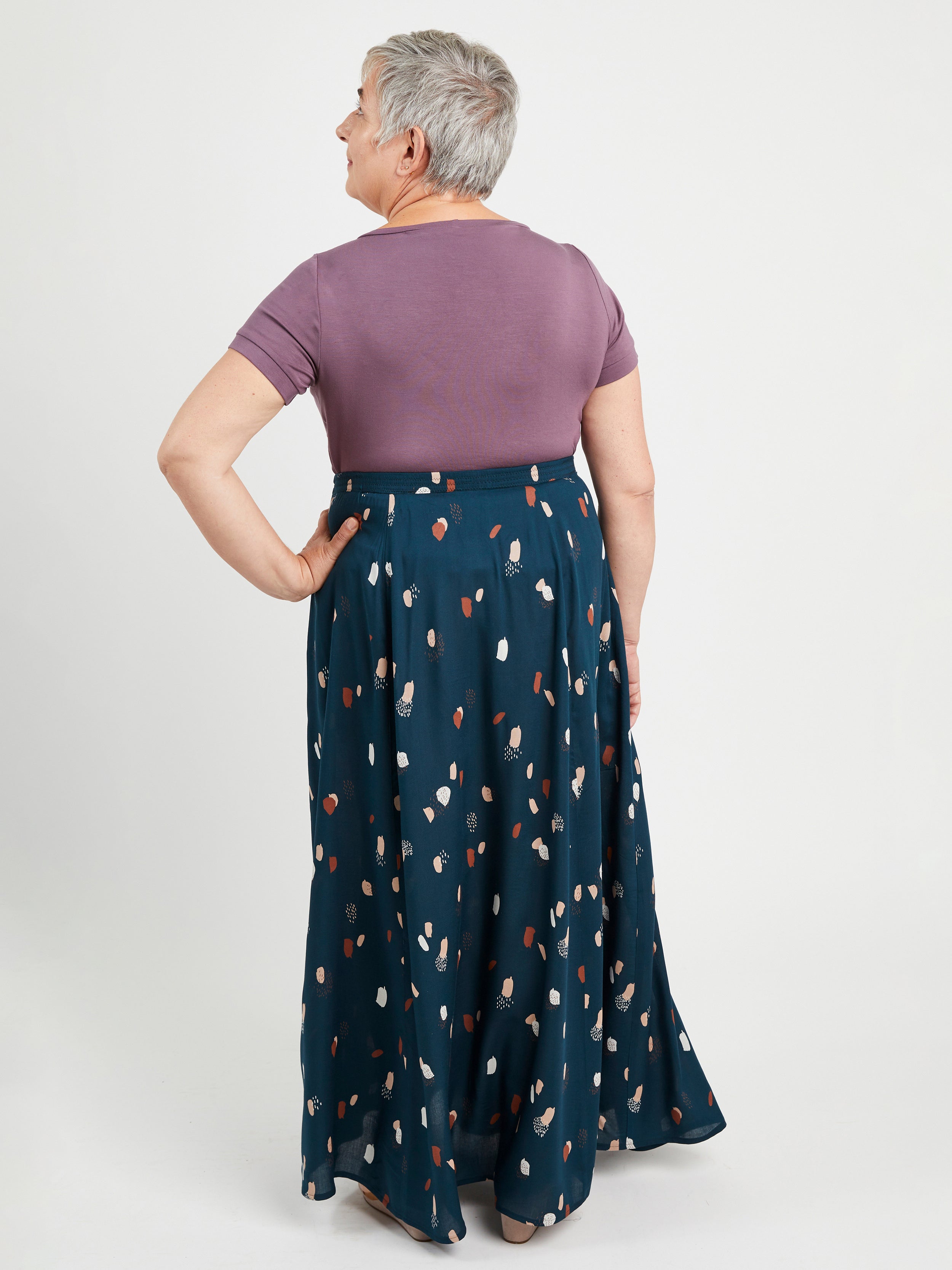Woman wearing a purple top and blue patterned skirt on a white background. This is the Holyoke Maxi Dress & Skirt sewing pattern from Cashmerette.