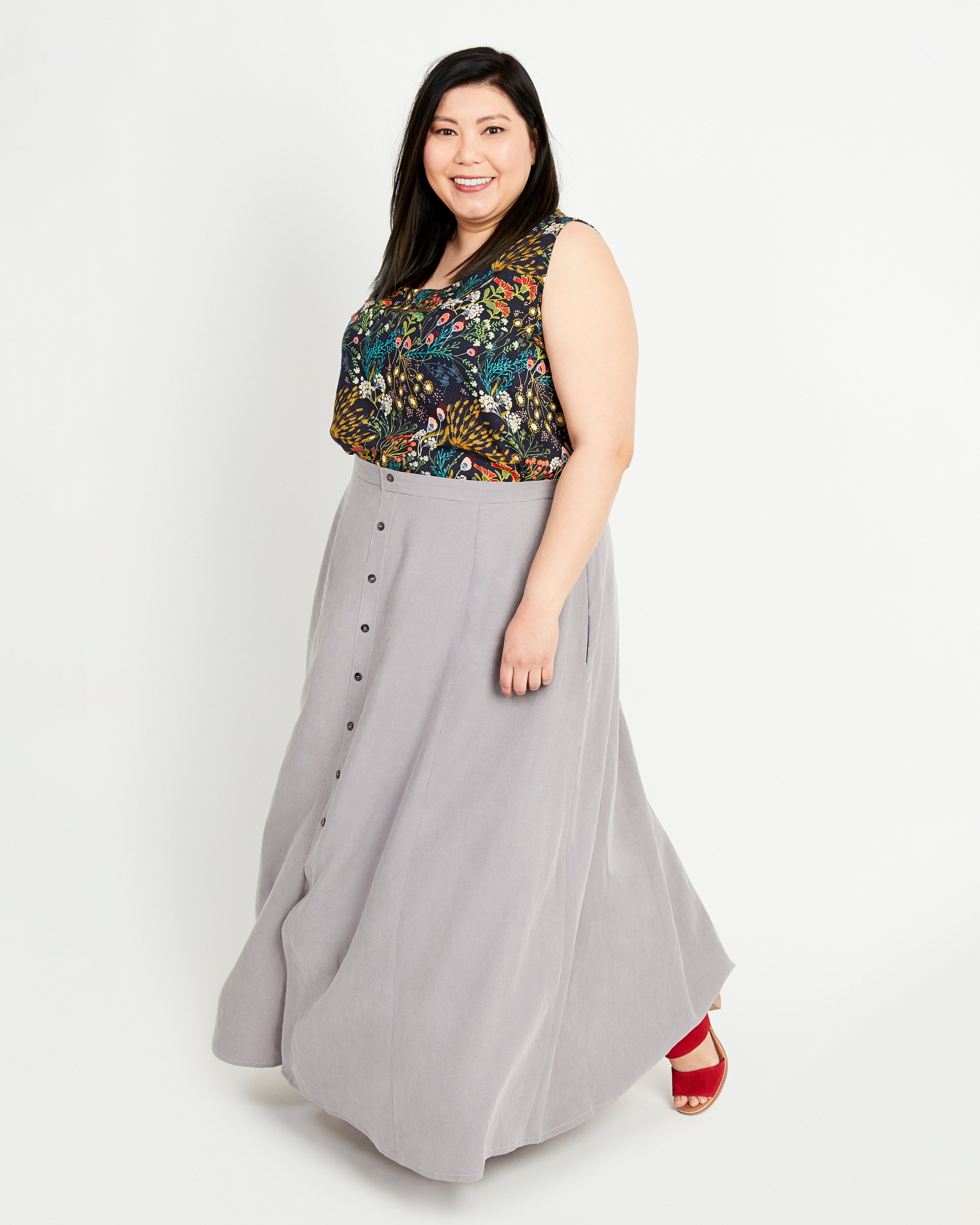 Woman wearing a floral top and gray skirt on a white background. This is the Holyoke Maxi Dress & Skirt sewing pattern from Cashmerette.