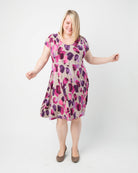 Woman wearing a floral dress on a white background. This dress is the Turner Dress sewing pattern from Cashmerette.